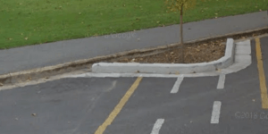 A carpark, with gutter, a path and grass